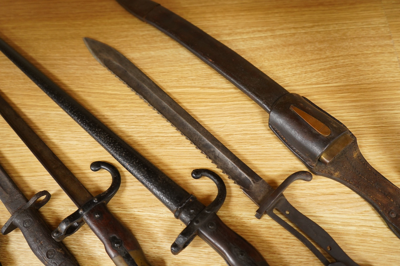 Seven bayonets; a speculative 20th century English bayonet of unknown type with broad arrow and other English type markings, together with a German butcher bayonet in scabbard (grips missing), a Gras bayonet and scabbard